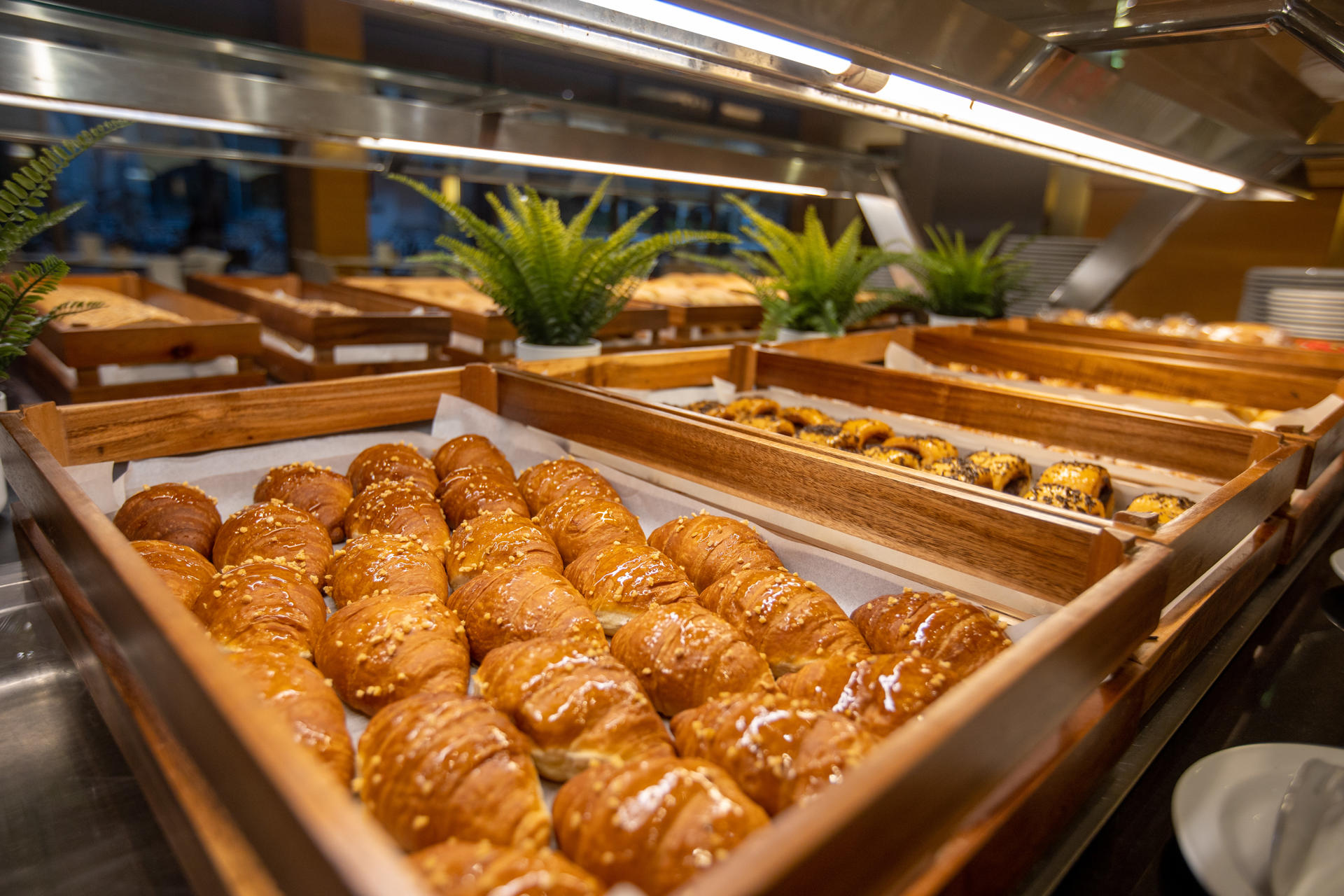 Wooden trays with ensaimadas, croissants and napolitanas.